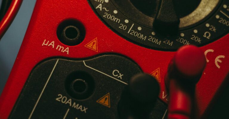 Detailed image of a red multimeter, showcasing measurement dial and connectors, ideal for tech enthusiasts.